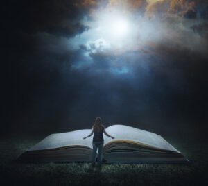 A woman standing in front of an open book.