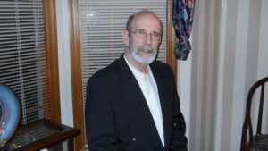 A man in a suit standing next to a window.