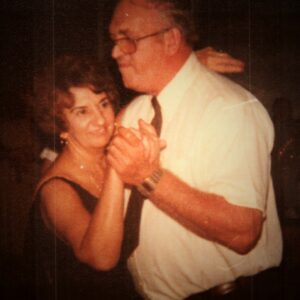 A man and woman dancing together in the dark.