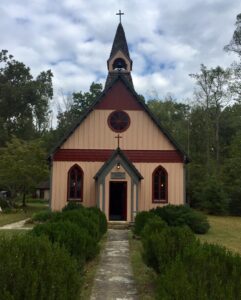 A church with a steeple and a clock on the front.