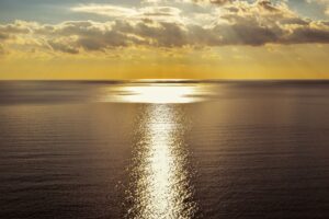 A sunset over the ocean with a large body of water