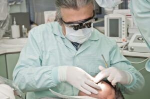 A dentist is working on the patient 's teeth.