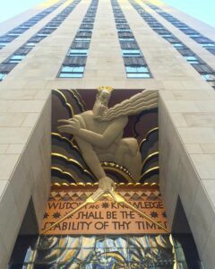 A statue of an angel on the side of a building.